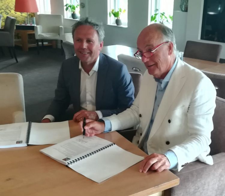 Arie-Jan de Ridder (De Ridder) en Ron de Graaf (voorzitter Golfclub Houtrak) tekenen het contract.